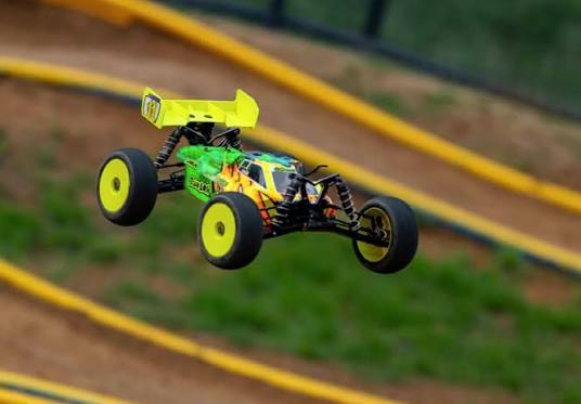 Buggy RC verde e amarelo saltando na pista